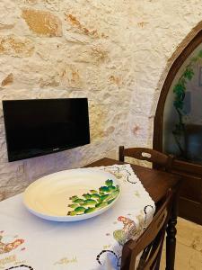 a plate on a table with a tv on a wall at La Pergola in Locorotondo