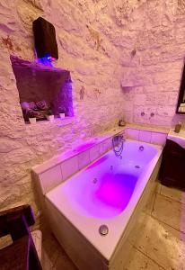a bath tub with pink lighting in a bathroom at La Pergola in Locorotondo
