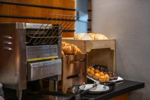 a coffee machine with bread and pastries on a counter at Holiday Inn Express Ramsgate – Minster by IHG in Minster