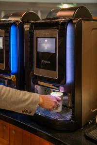 a person is holding a cup in front of a microwave at Holiday Inn Express Ramsgate – Minster by IHG in Minster