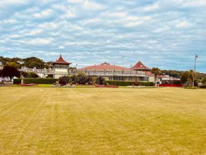 a large grass field in front of a large building at Beautiful spacious old schoolhouse with stunning sea views and beach nearby in Port Bannatyne