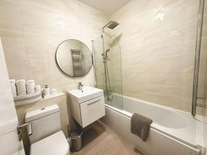 Un baño con inodoro, lavabo y espejo. en Superb Flat in South Kensington, en Londres 18 fotos más