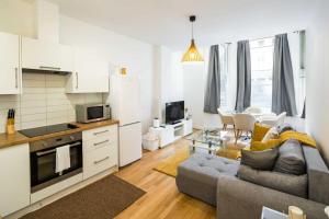Una cocina y una sala de estar con un sofá y una mesa. en Superb Flat in South Kensington, en Londres