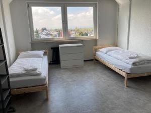 two beds in a room with a window at Monter24- HK2 große Monteurs Wohnung Mainz, Wiesbaden, Rüsselsheim, gute Anbindung in Hochheim am Main