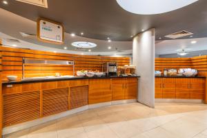 a kitchen with wooden cabinets and a counter in a restaurant at Holiday Inn Express Ramsgate – Minster by IHG in Minster