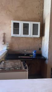 een keuken met een fornuis, een wastafel en ramen bij Resteg área de lazer in Serrana