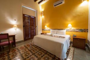 a hotel room with a bed and a desk at Hotel del Gobernador in Mérida +115 photos