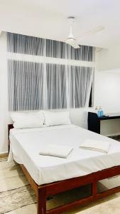 a bedroom with a large bed with white sheets at BSG Stay Calangute Beach Road Goa Hotel in Calangute