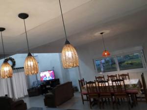 una sala de estar con 3 luces colgando del techo en Casa com piscina / Na quadra do mar Torres-RS en Torres