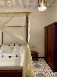 a bedroom with a bed with a canopy at Villa Kipara - Beachfront with Private Pool in Pwani Mchangani