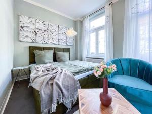 um quarto com uma cama e um vaso de flores sobre uma mesa em Homestayplus Schwerin em Schwerin