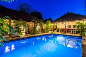a swimming pool in front of a house at night at Senang Luxury Villa in Gili Air