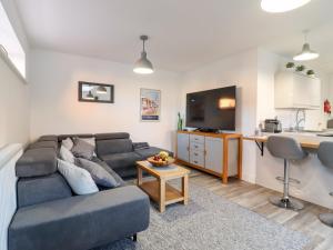 a living room with a couch and a kitchen at Little Haven in Frinton-on-Sea