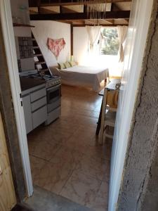 - une cuisine avec cuisinière et un lit dans une chambre dans l'établissement Mana, à San Martín de los Andes