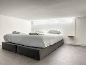 una camera da letto con un grande letto con lenzuola bianche di La Suite Duhamel - Au pied de la Gare - Au Calme a Rennes