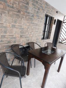 a table and chairs in front of a brick wall at El refugio paisa in Medellín