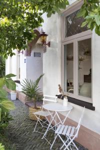 een witte tafel en stoelen op een patio bij Magnolia Spring Boutique Apartments in Bergen