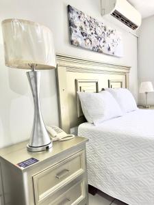 ラ・セイバにあるGran Hotel Parisのベッドルーム1室(ベッド1台、ナイトスタンドのランプ付)