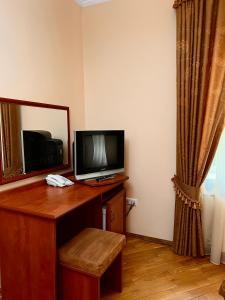 a room with a desk with a television and a mirror at База відпочинку ШИПОВЕЦЬ in Poroškov