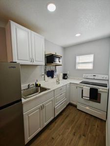 a kitchen with white cabinets and a sink at Lovely unit central location in St. Petersburg