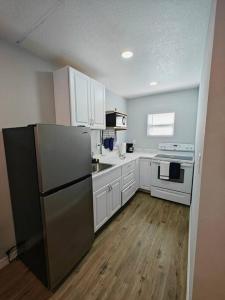 a kitchen with white cabinets and a black refrigerator at Lovely unit central location in St. Petersburg