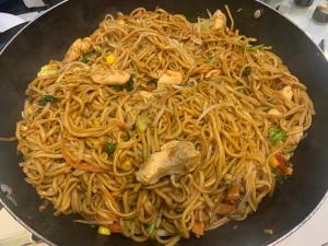 a wok filled with noodles and meat at Fully Air-Conditioned Bedroom w 2 Double Beds & King Size Sofa Bed w Ensuite Bathroom Near Grand Union Canal - FREE Parking in Southall