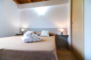 1 dormitorio con 1 cama con toallas en Le case del Carmine con giardino e parcheggio a Tropea, en Tropea