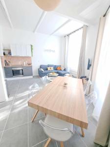 - un salon avec une table en bois et un canapé dans l'établissement Appartement lumineux , Carpentras centre, à Carpentras