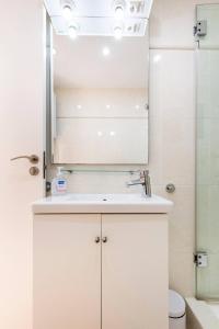 y baño con lavabo y espejo. en Sitges Seafront Ribera Apartment, en Sitges