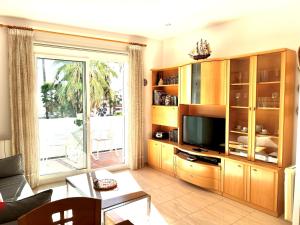 a living room with a large entertainment center with a television at Sitges Seafront Ribera Apartment in Sitges
