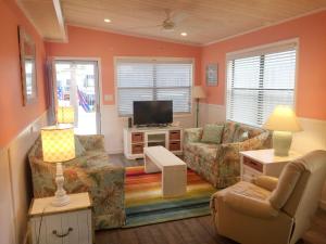 a living room with a couch and a tv at Venture Out 41 Gulf Loop 2bd 1ba WITH GOLF CART in Panama City Beach