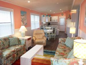 a living room with two couches and a kitchen at Venture Out 41 Gulf Loop 2bd 1ba WITH GOLF CART in Panama City Beach