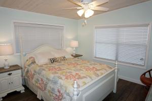 a bedroom with a bed and a ceiling fan at Venture Out 41 Gulf Loop 2bd 1ba WITH GOLF CART in Panama City Beach