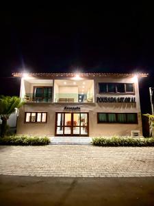 een wit gebouw met 's nachts een bord bij Pousada Litoral Paraty in Paraty