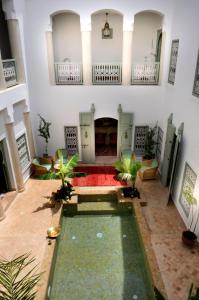 una piscina al centro di una stanza con un edificio di Riad Les Hibiscus a Marrakech