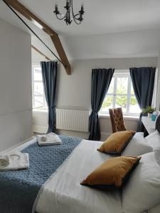 ein Schlafzimmer mit einem großen weißen Bett mit braunen Kissen in der Unterkunft Kings Arms Hotel in Kirkby Lonsdale