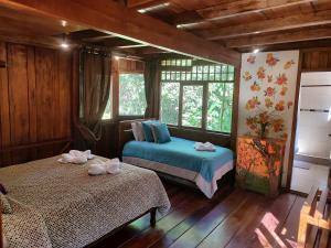 a bedroom with two beds and a window at Mindo Garden Lodge and Wildlife Reserve in Mindo