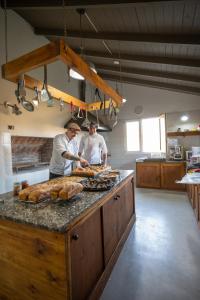 Zwei Männer bereiten Essen in einer Küche vor. in der Unterkunft La Posta de los Toldos in Perito Moreno