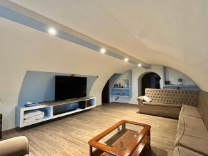 een woonkamer met een bank en een tv bij Casa Palacio El Trasquilon in Cáceres