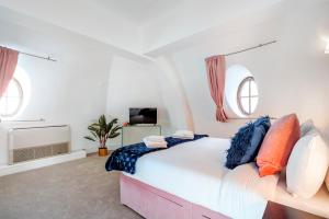 a bedroom with a large bed and two windows at Welcome London - Trafalgar Square in London