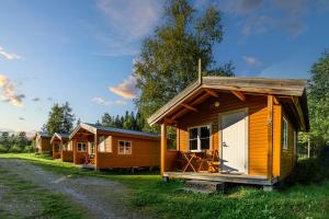rząd drewnianych domków na polu w obiekcie Korsbakken Camping w mieście Isfjorden