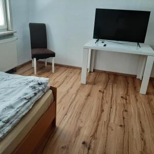 a bedroom with a desk with a computer and a chair at Unterkunft für Monteure in Schwallungen +4 photos
