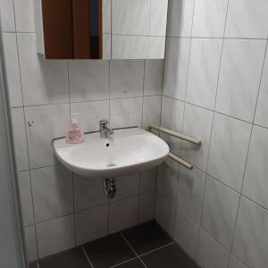 a white sink in a bathroom with white tiles at Ferienhaus Thüringen Unterkunft für 6 Personen in Schwallungen