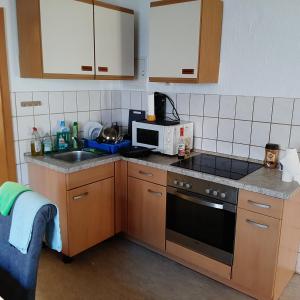 a small kitchen with a sink and a microwave at Unterkunft für Monteure in Schwallungen