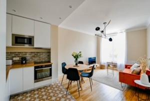 eine Küche und ein Wohnzimmer mit einem Tisch und einem Sofa in der Unterkunft Mytripinparis - Fully renovated 2 bedrooms in Neuilly-sur-Seine