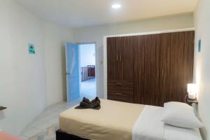 1 dormitorio con 1 cama grande y armario de madera en My place in paradise, en San Cristobal