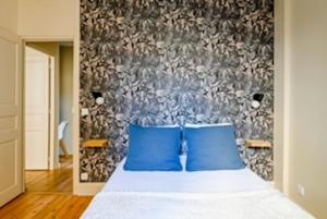 ein Schlafzimmer mit einem Bett mit zwei blauen Kissen in der Unterkunft Mytripinparis - Fully renovated 2 bedrooms in Neuilly-sur-Seine