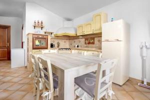 a kitchen with a table and chairs and a refrigerator at Villino Tiriddò Porto San Paolo in Porto San Paolo