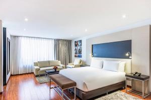 a bedroom with a large bed and a living room at Jazz Apartments Luxury Suites in Bogotá +51 photos