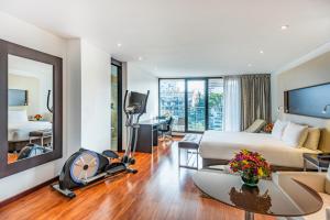 a hotel room with a large bed and a desk at Jazz Apartments Luxury Suites in Bogotá